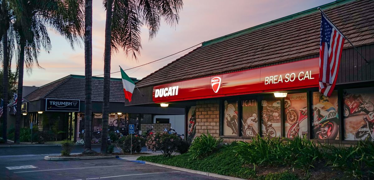 Southern California Motorcycles in Brea at dusk, with the Triumph and Ducati storefronts