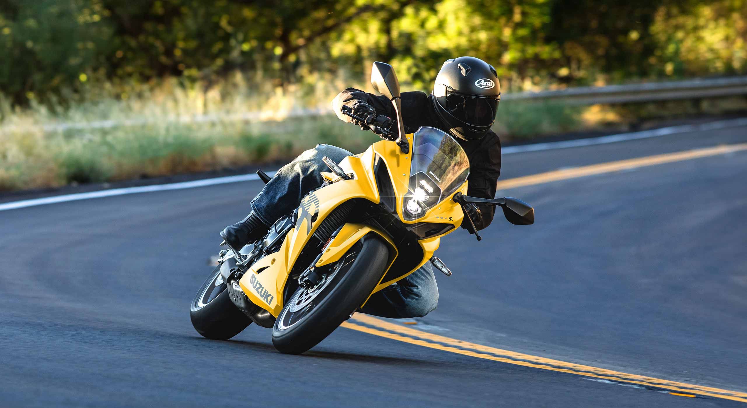 A GSX-8R leaned into a corner on a mountain road, photographed by Suzuki