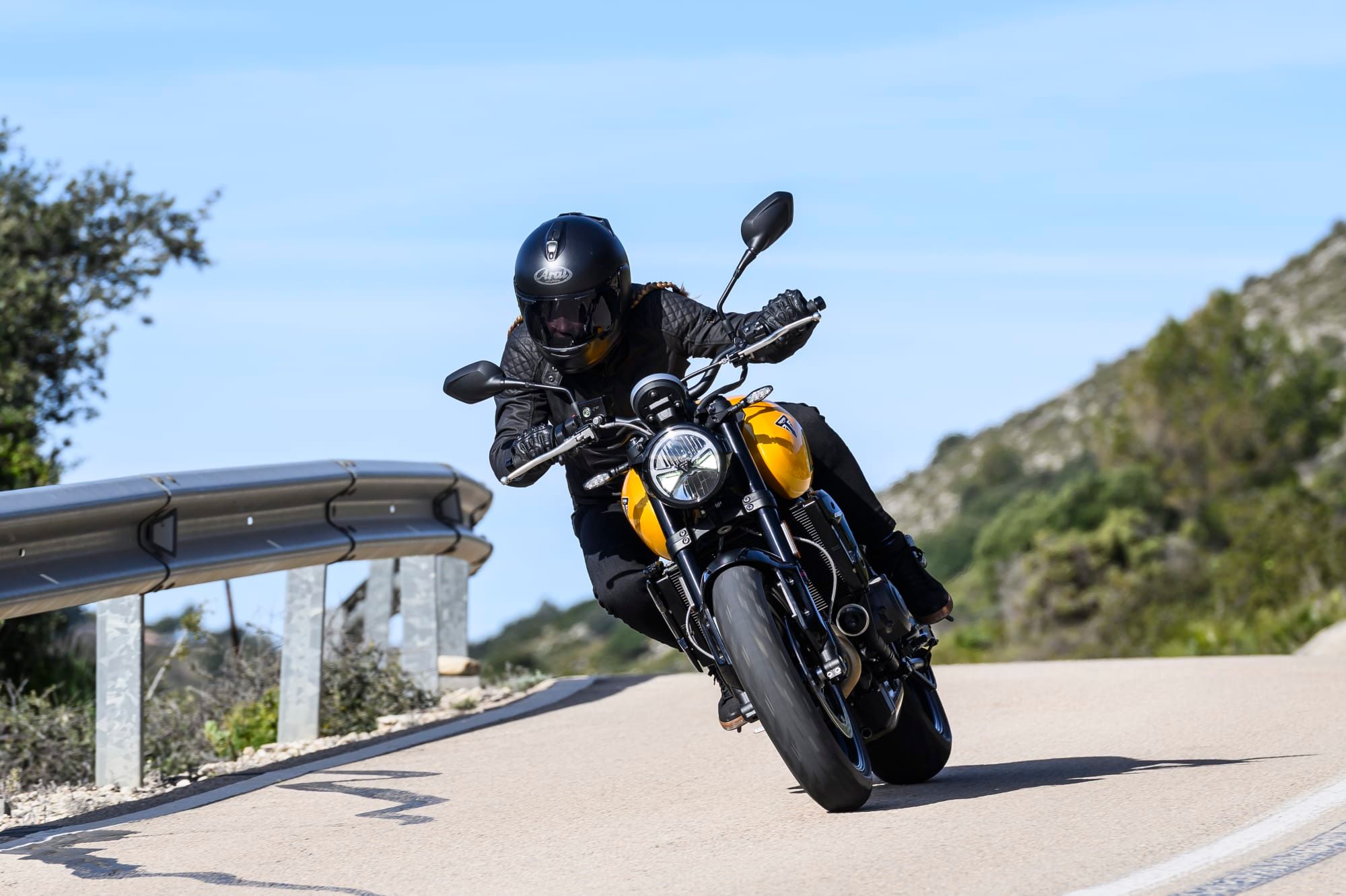 A 2026 Trident 660 in Cosmic Yellow on a coastal road, photographed by Triumph