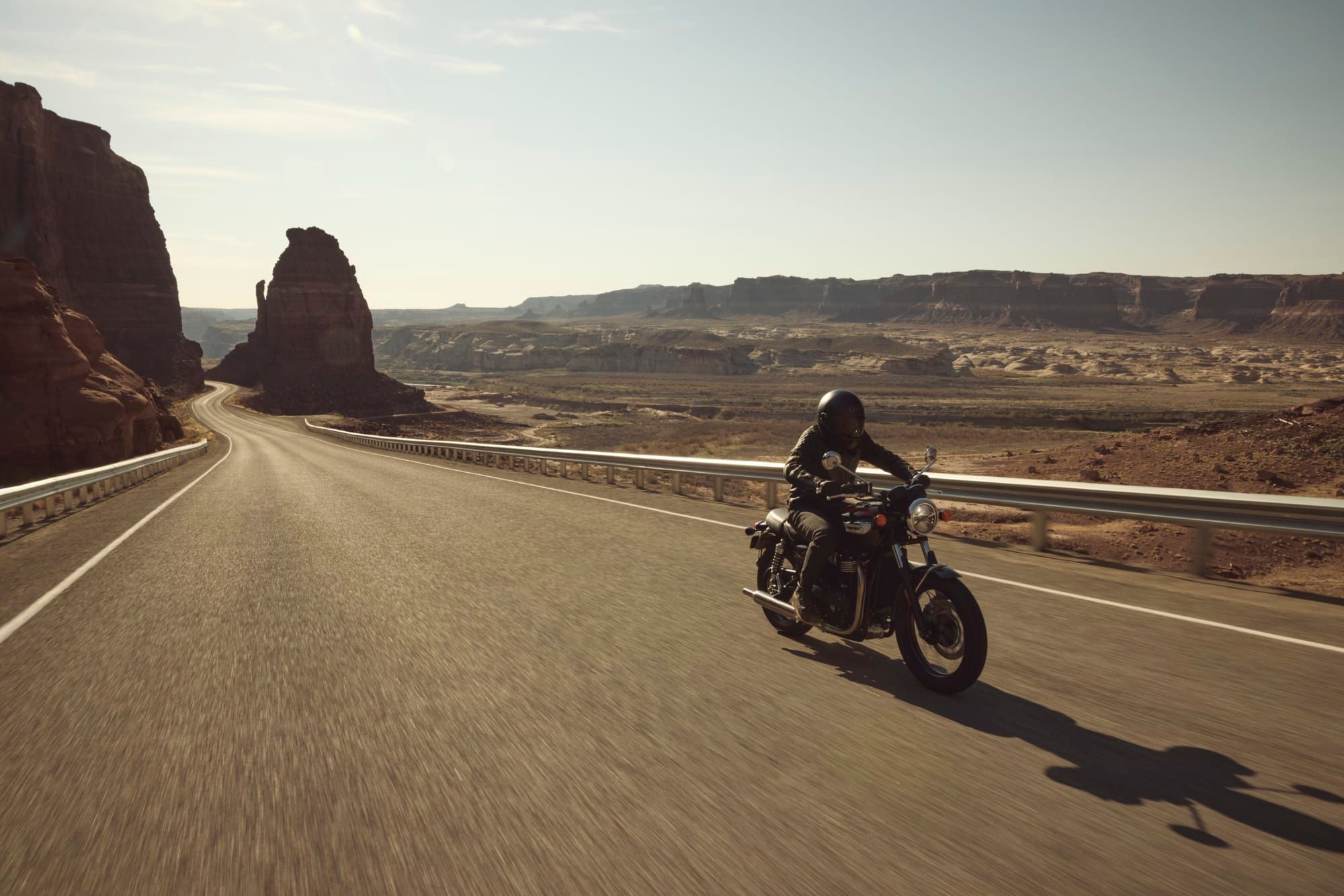 A Bonneville T100 on an open desert highway, photographed by Triumph