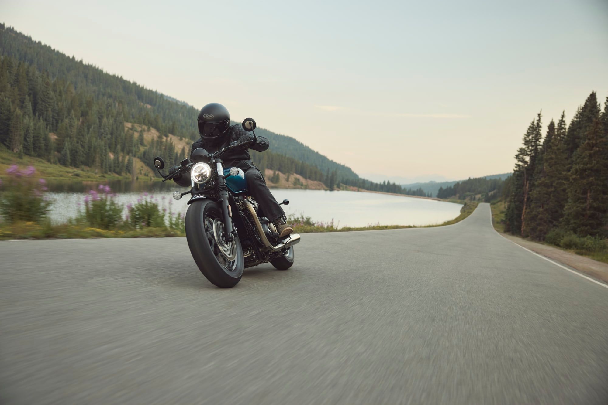 A rider on a 2026 Bonneville Bobber on a lakeside road