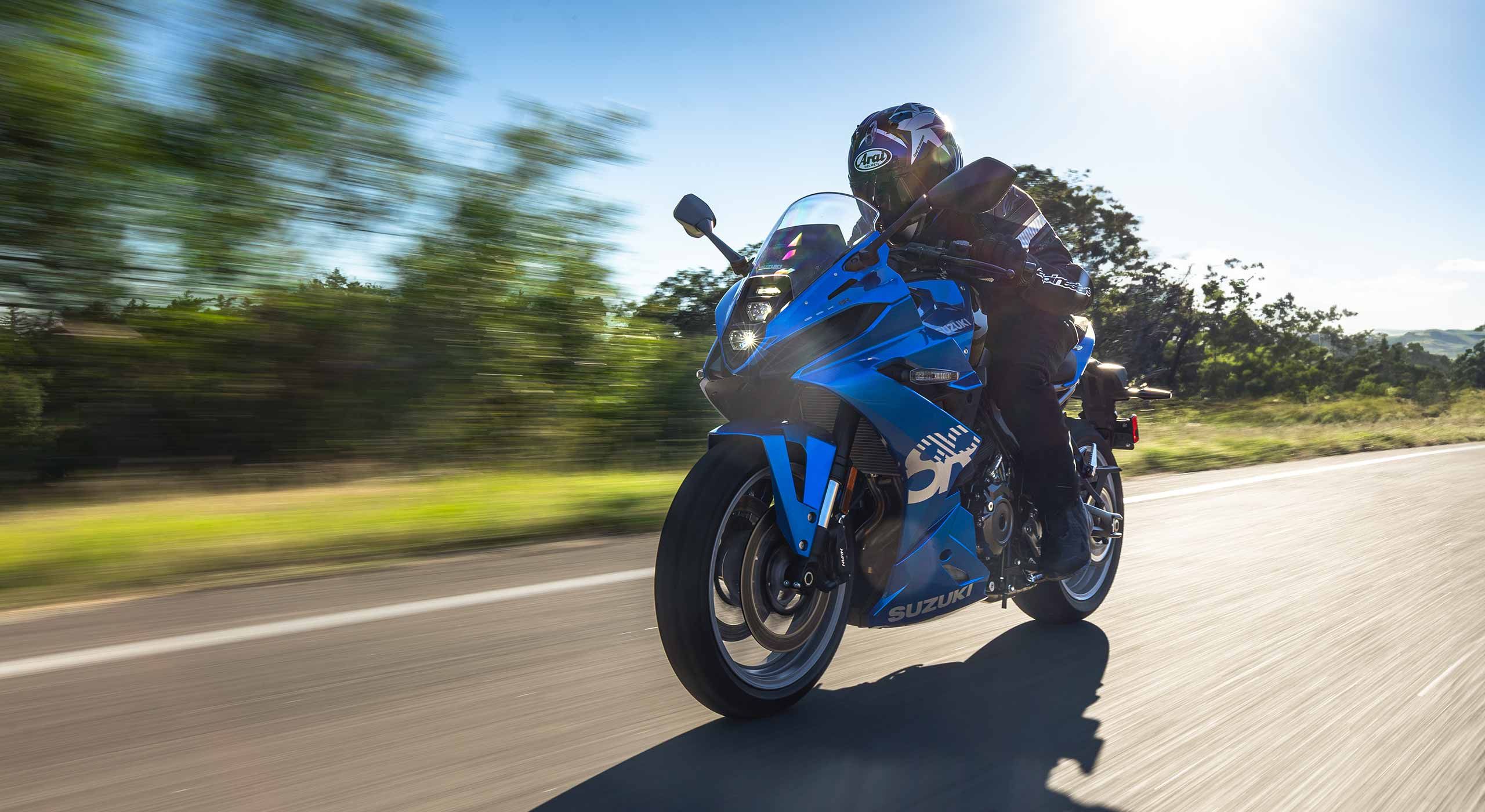 A GSX-8R ridden on a tree-lined road, photographed by Suzuki